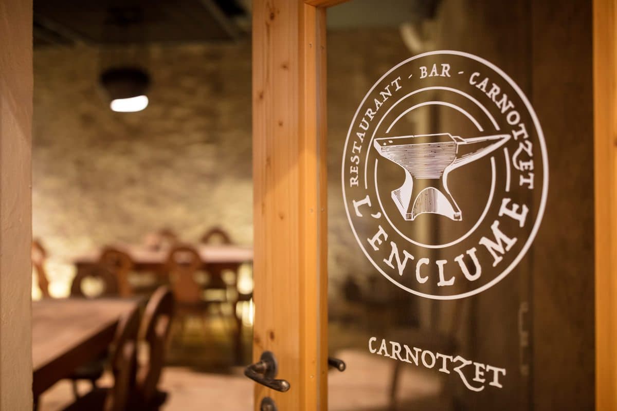 Le carnotzet de L'Enclume à Charmey, logo enclume gravé sur la porte vitrée